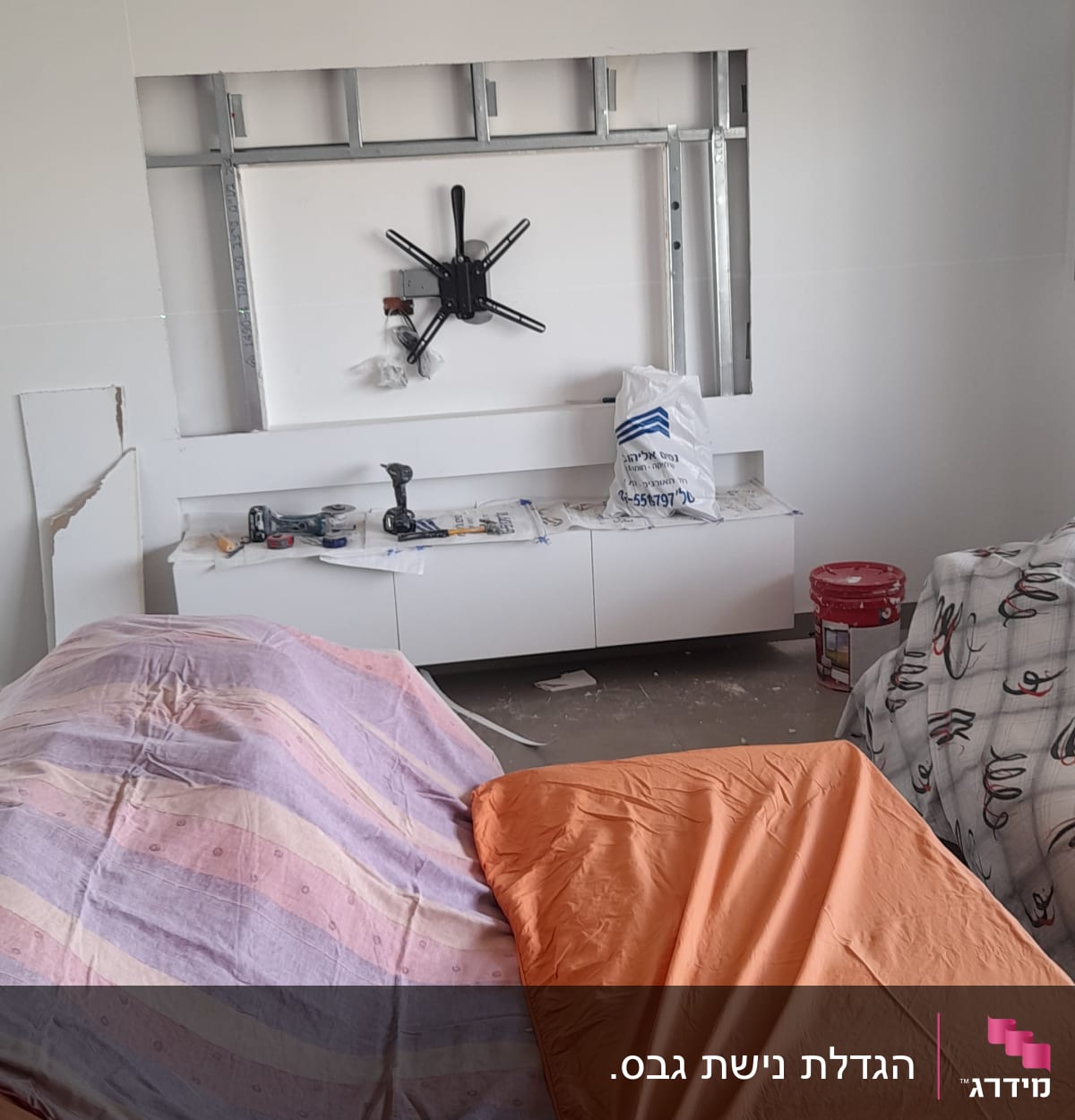 קיר גבס עם מתקן לטלוויזיה וכלי עבודה